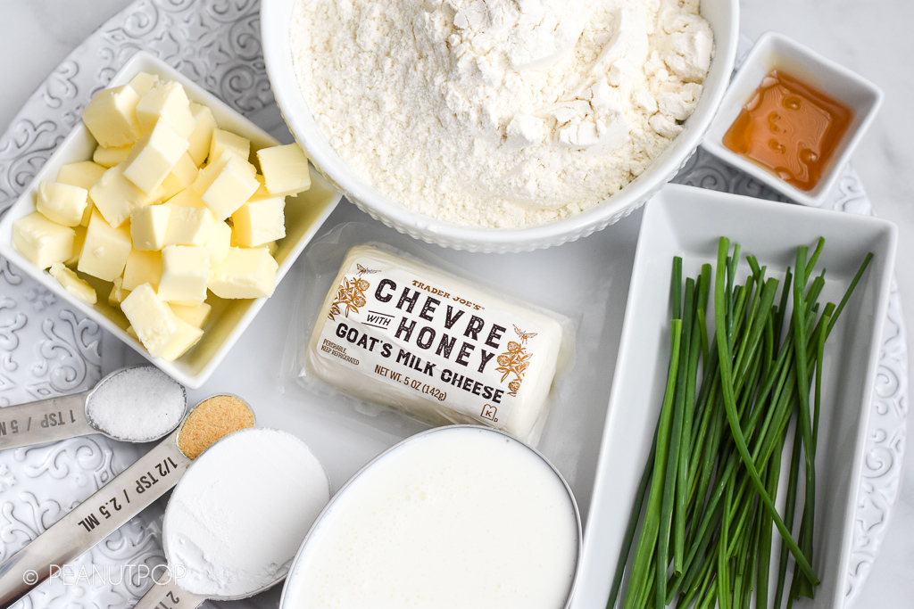 Ingredients to make goat cheese and chive biscuits.  Flour, honey, chives, butter, salt, garlic powder, baking powder, buttermilk, and goat cheese.